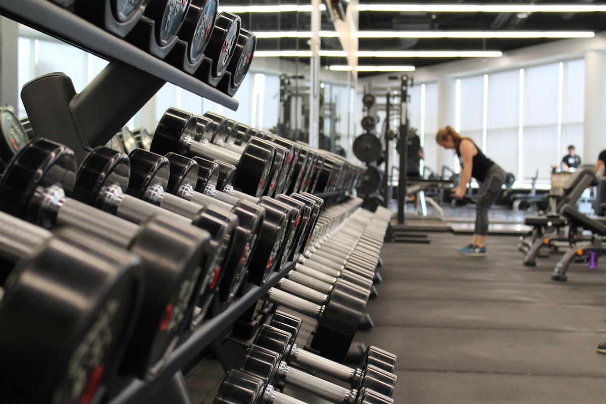 Focused adult lifting weights in a gym with natural lighting