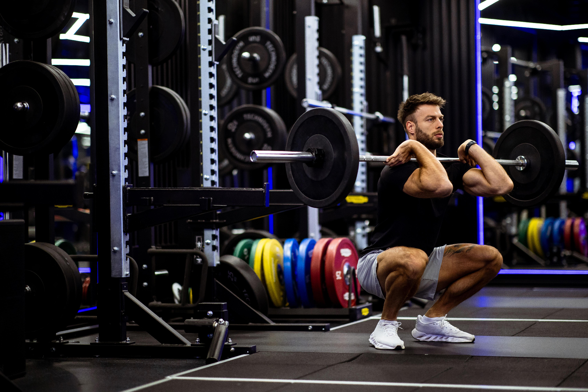 Man performing a front squat with proper form in a gym